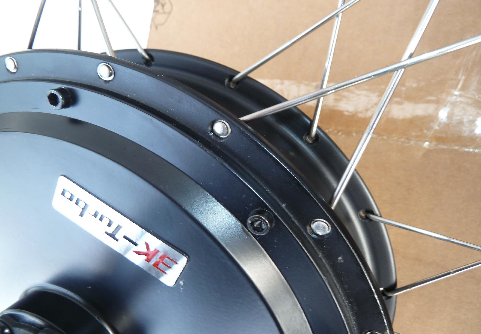 The spoke holes of the MXUS motor a a little bit too big for regular spokes. Washers help.