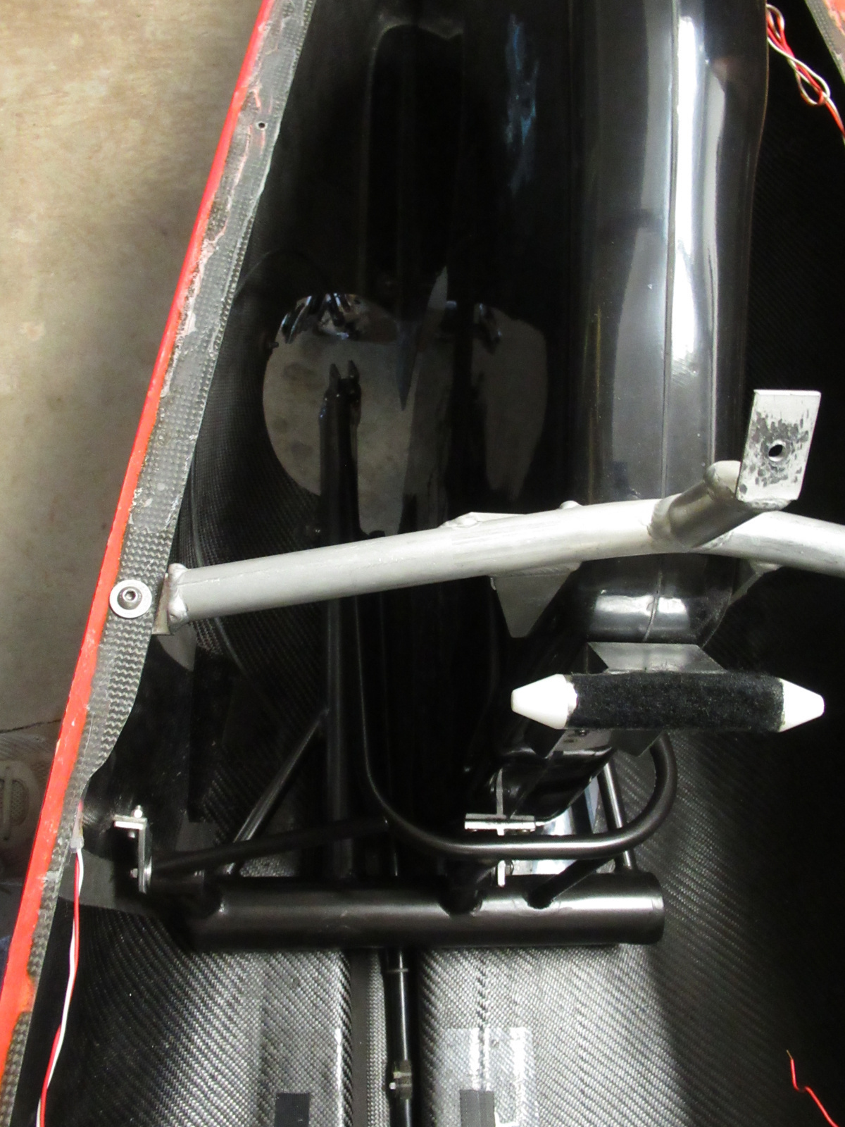 View inside the vehicle, looking toward the rear, behind seat (which has been raised). New swingarm installed.