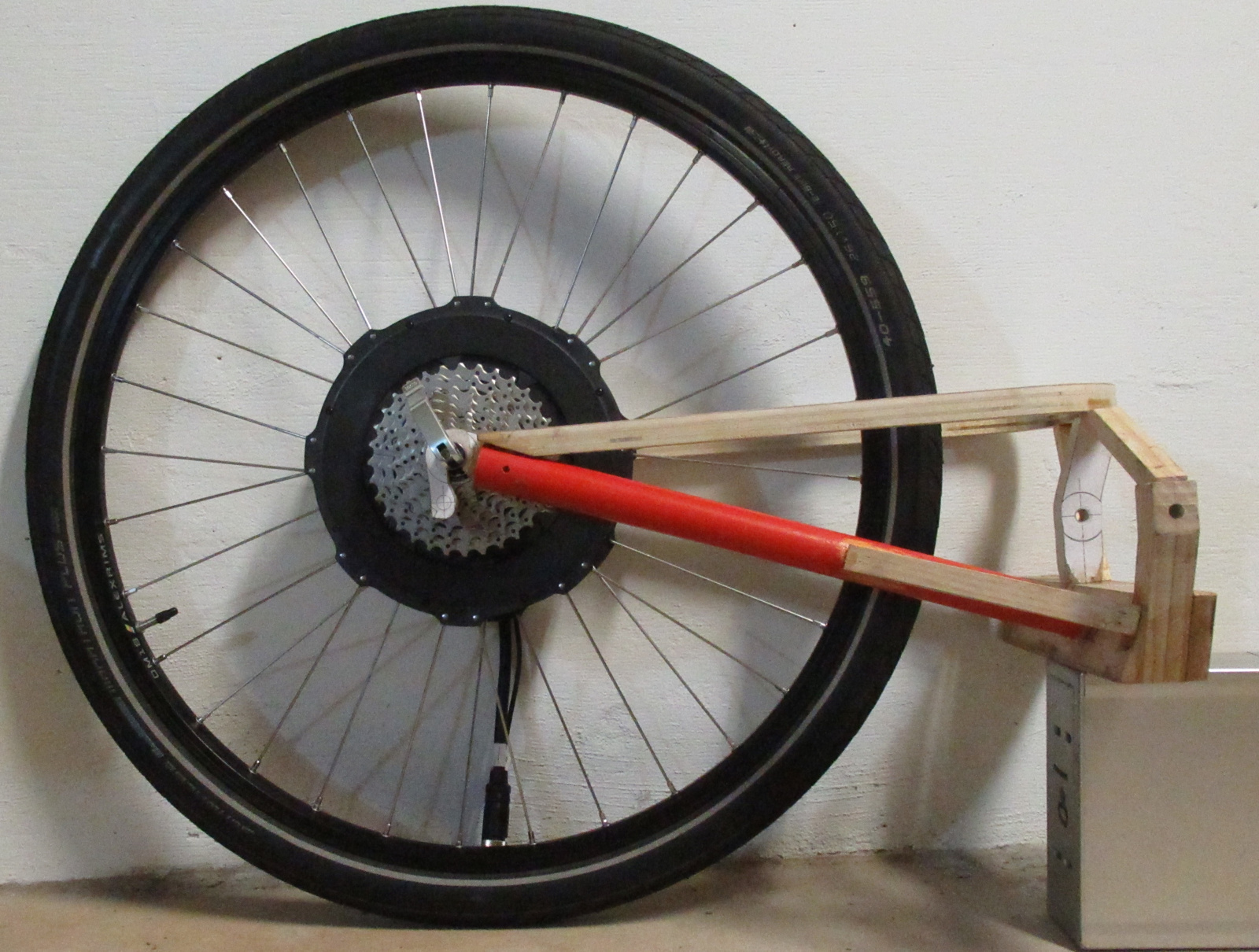 I acquired an All-Axle motor laced to a 26-inch wheel by Grin. Here it is mounted with the mockup of the new rear swingarm.