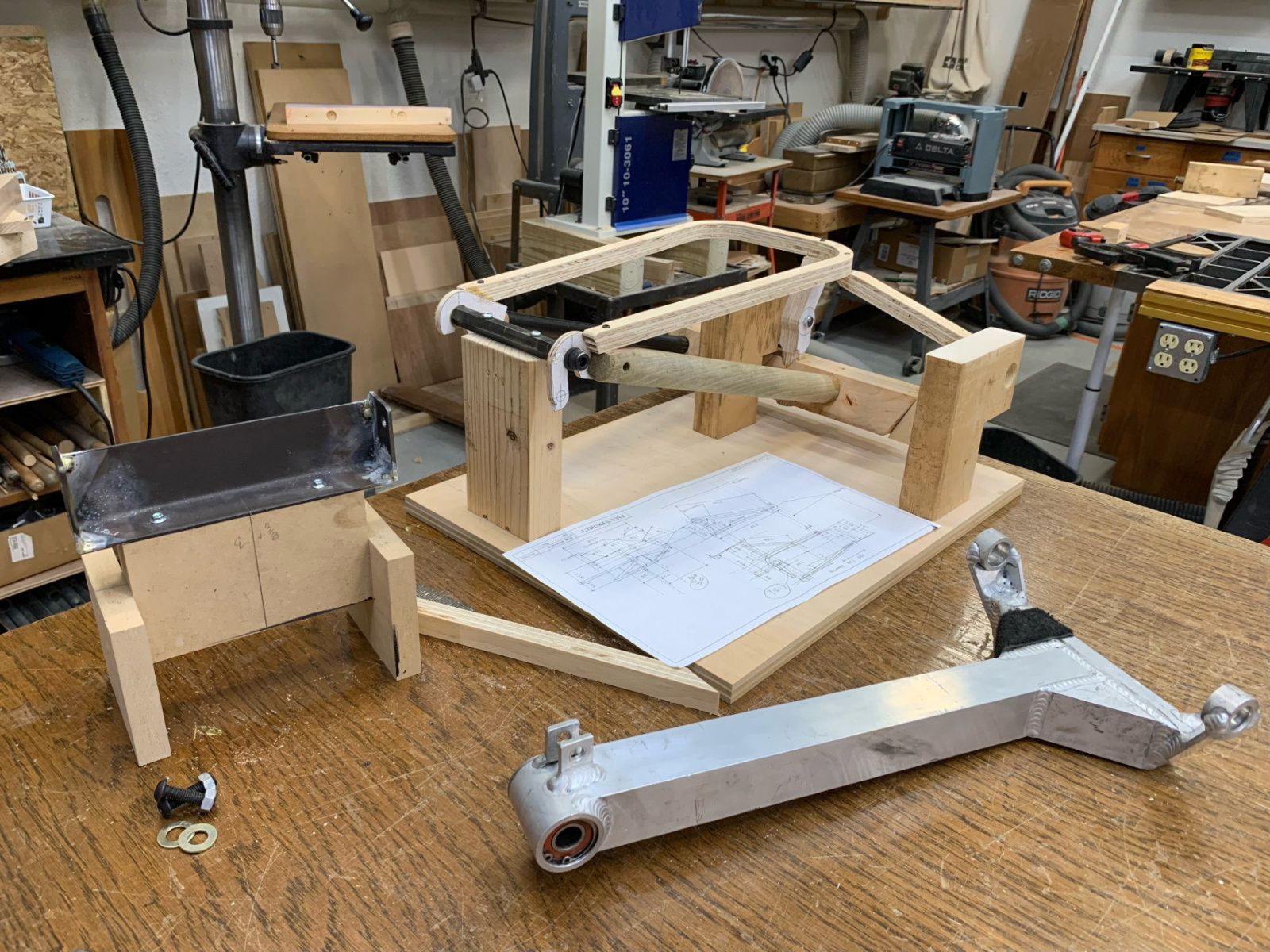 The old aluminum swingarm is seen in the foreground. Behind it is a wooden mockup of the new design that we would use to test fit in the vehicle, before cutting any metal.